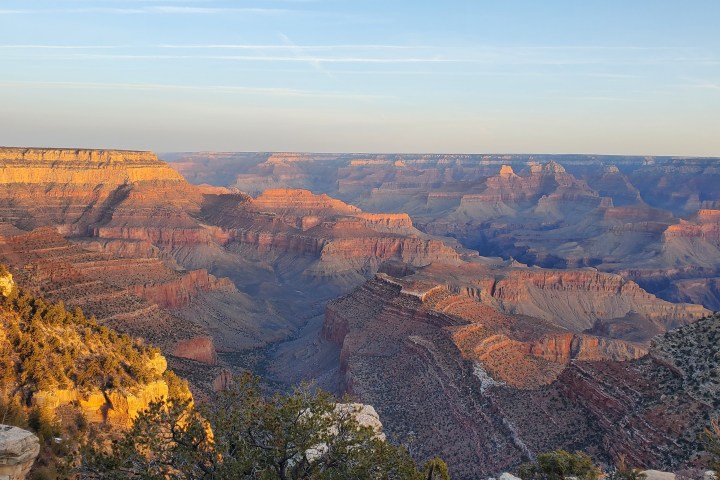 Grand Canyon view at sunset with layered rock formations and clear sky.