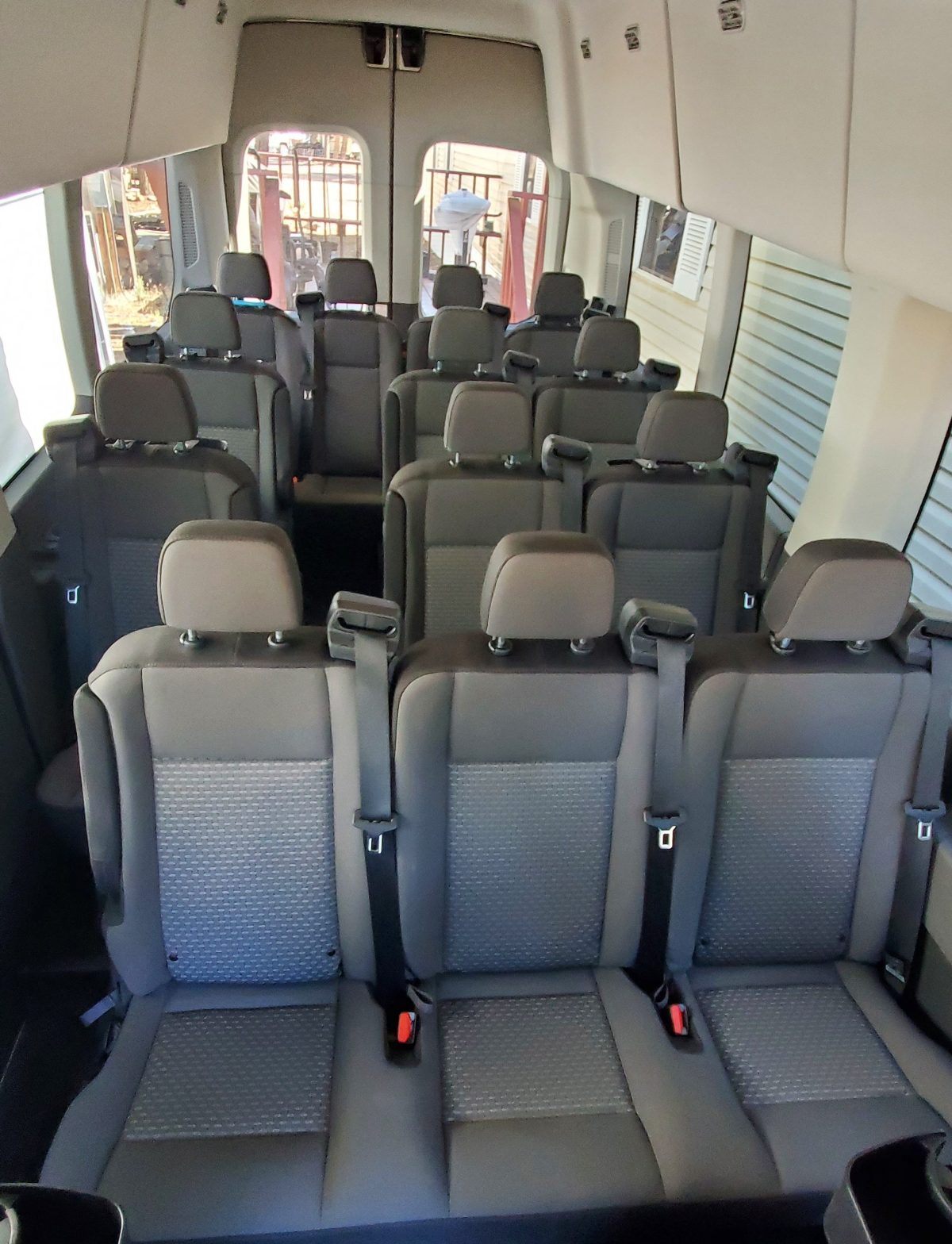 Interior of a van with multiple rows of gray seats.